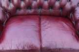 Chesterfield, antik burgundi színű bőr ülőgarn.