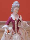 Csipkézett ruhájú porcelánbaba örökségből